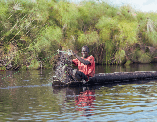 A man fishes aboard a canoe near Old Fangak, located alone one of the world's largest wetlands, the Sudd region.