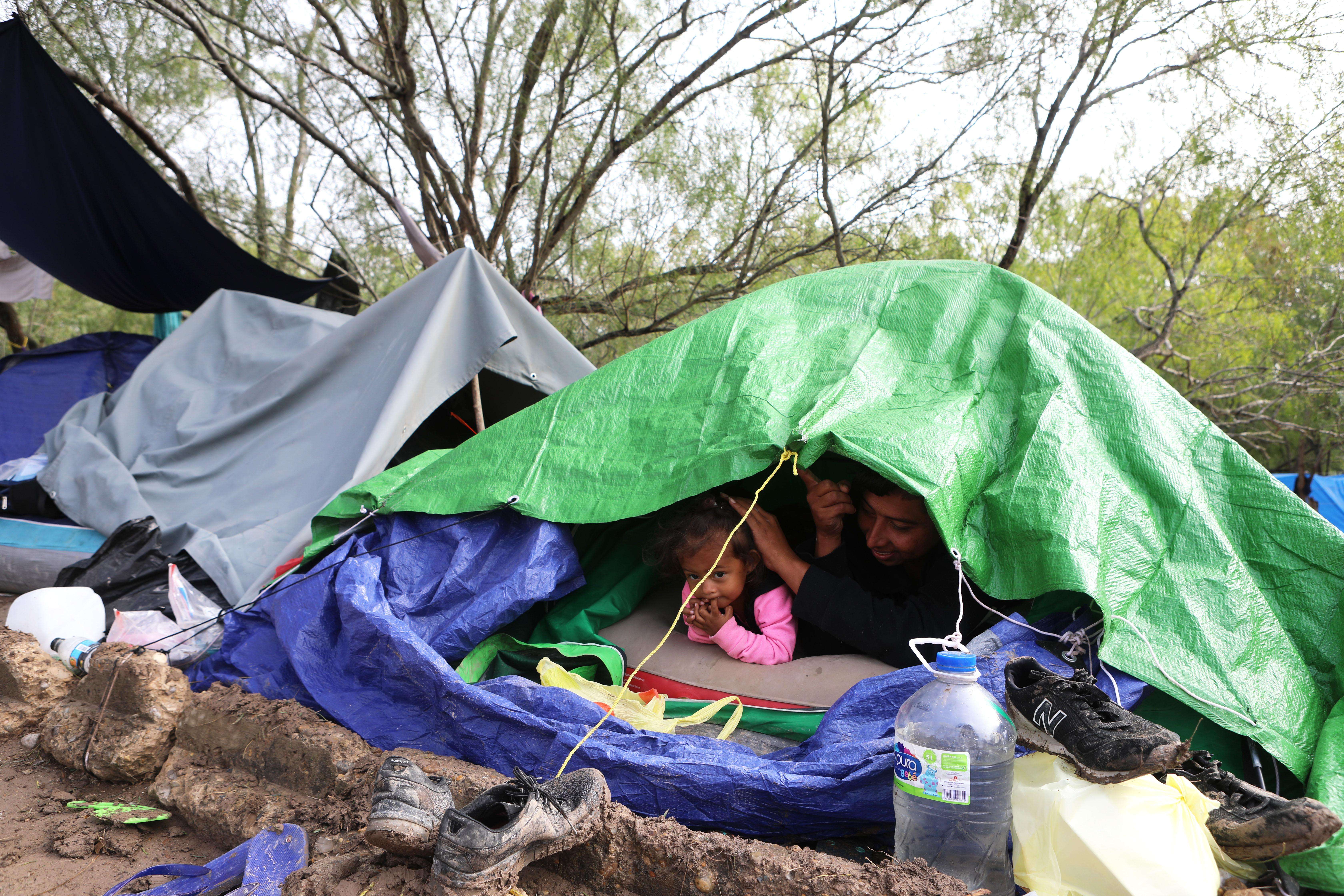 A family under plastic sheeting in Matamoros