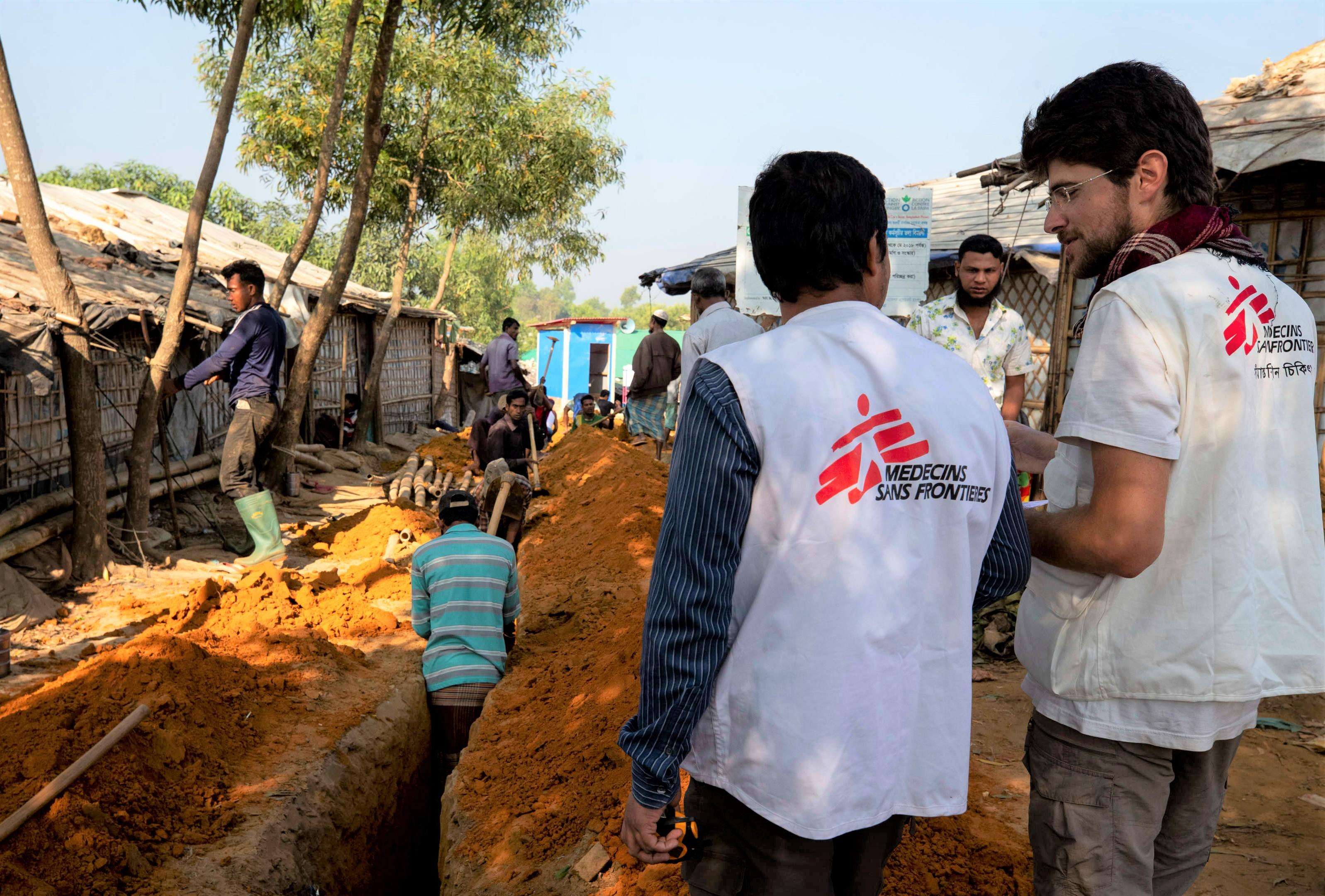 Paolo and Chandon, MSF water and sanitation logisticians, in front of the excavations for the sediment of pipes carrying water in camp 1 in Kutupalong and Balukali areas.