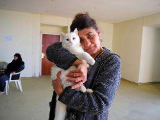 A displaced woman in South Lebanon holding a cat.