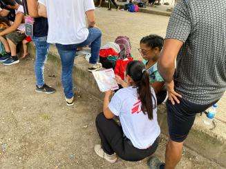 An MSF worker talks with migrants who have exited the Darien Gap in Costa Rica 