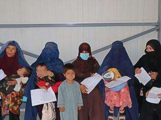 Caretakers listen to the health promotion session inside the triage waiting area of the Paediatric ward at the Mazar-i-Sharif Regional Hospital.