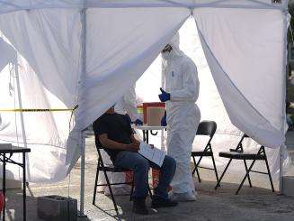 A nurse gives a patient a thumbs-up after completing a free test for COVID-19 at a mobile clinic in Immokalee, Florida.