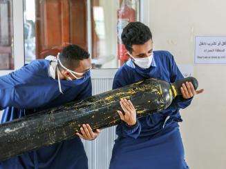 Workers carry an oxygen cylinder to the intensive care unit.