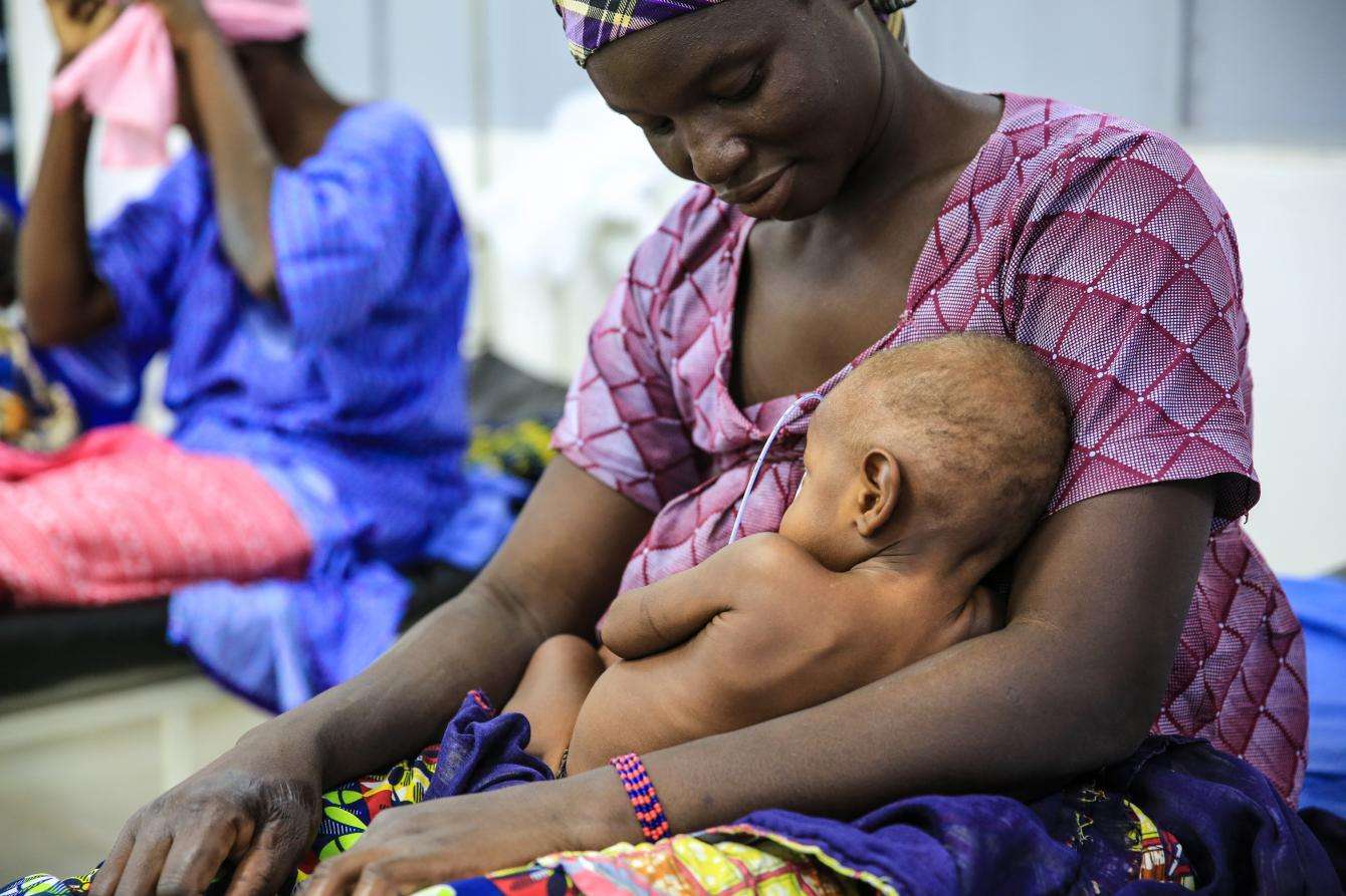 A mother holds her child recovering at the facility