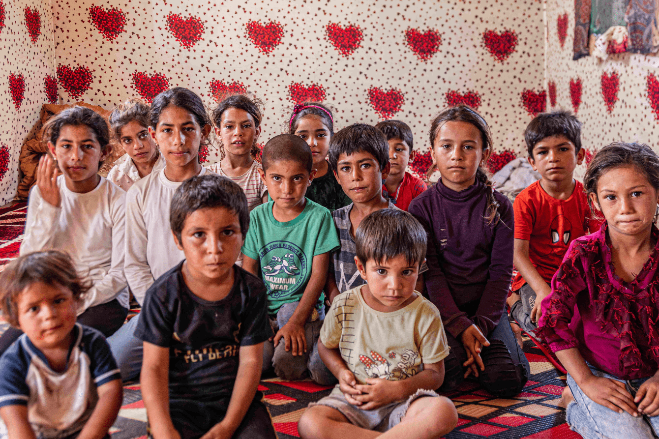 Children sit in a room with hearts on the walls in Lebanon.