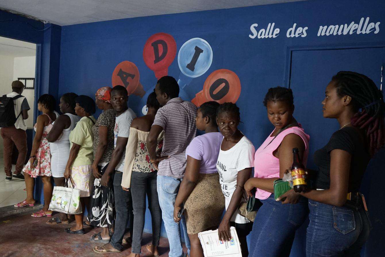 People queue during an MSF distribution of soap and mosquito nets in an internally displaced people (IDP) camp in Port-au-Prince, Haiti. 550 people live in the building, a school that delivers training during the day.