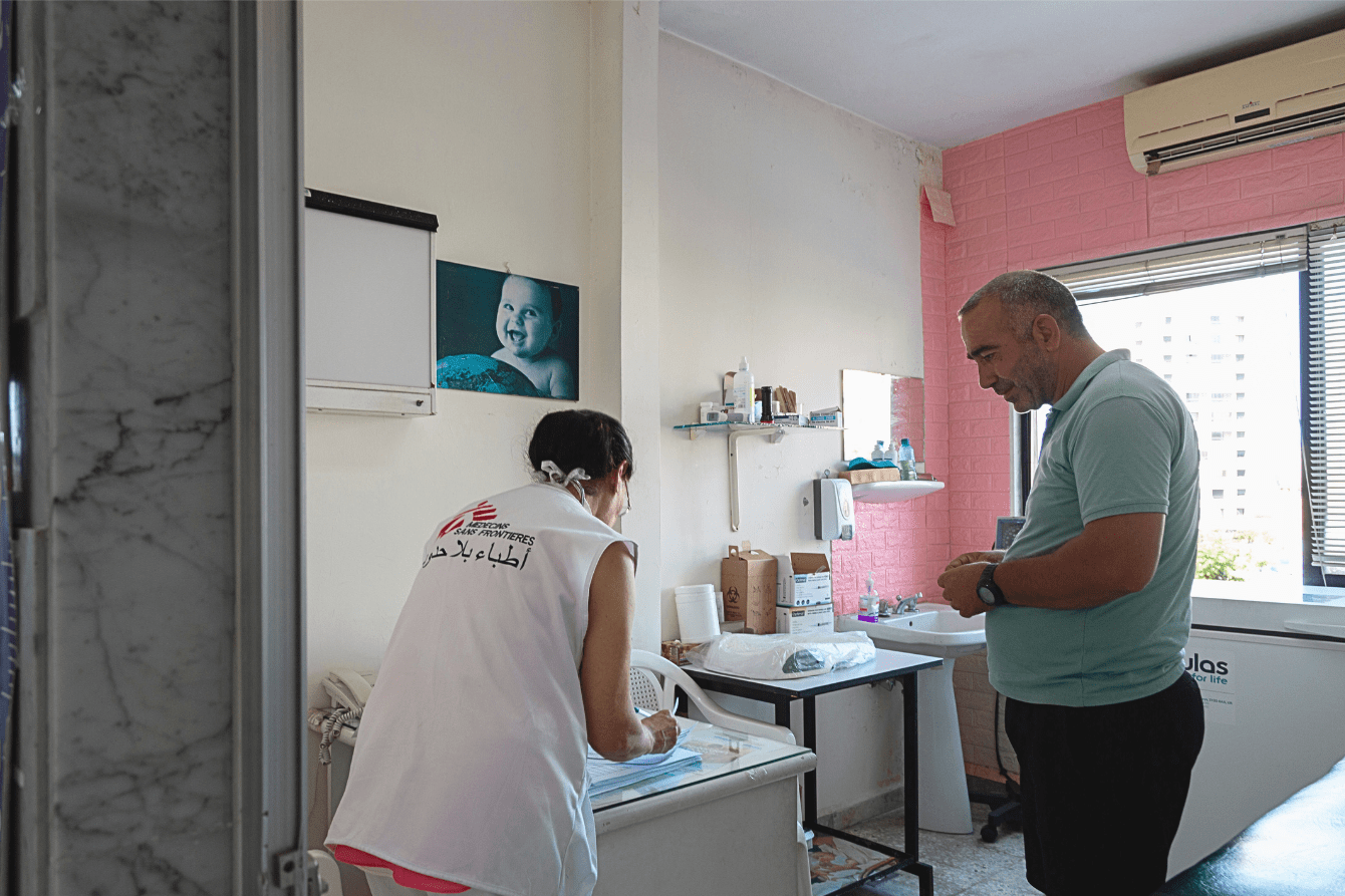 An MSF staff member speaks with a patient in Saida, Lebanon.