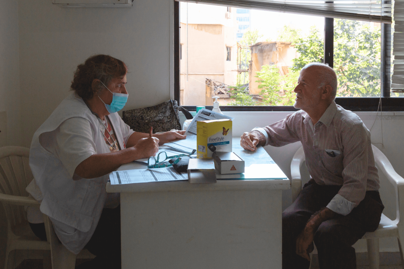 Hassan, a displaced Lebanese man, speaks with an MSF staff member in Saida.