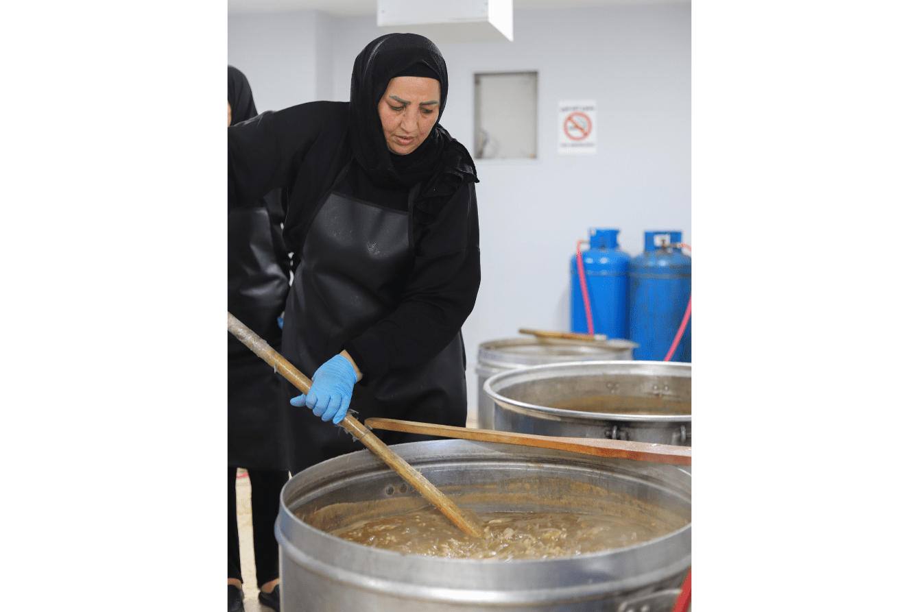 A woman cooks a meal at Azarieh shelter in Lebanon.