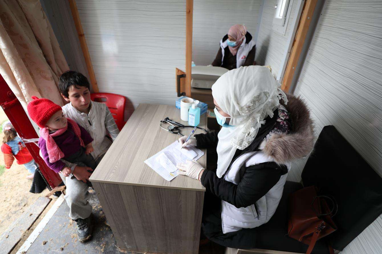 An MSF nurse talks with a young boy Northwest Syria