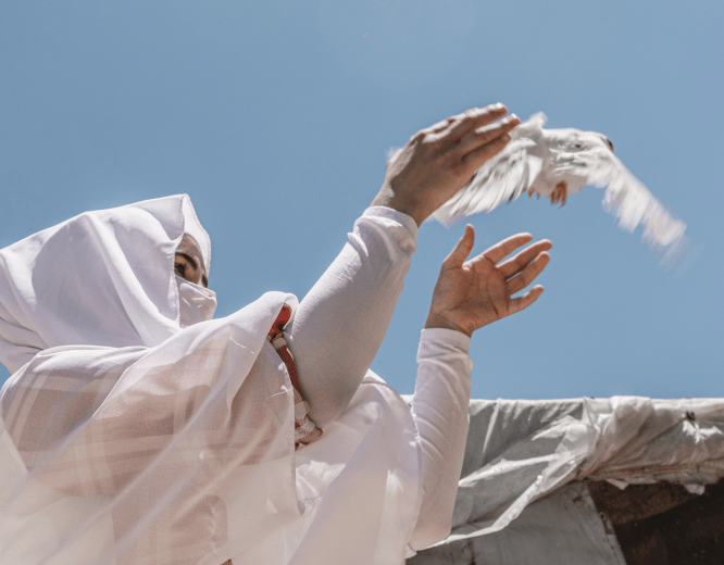 A woman releases a dove into the sky in Lebanon.