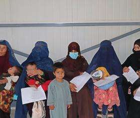 Caretakers listen to the health promotion session inside the triage waiting area of the Paediatric ward at the Mazar-i-Sharif Regional Hospital.